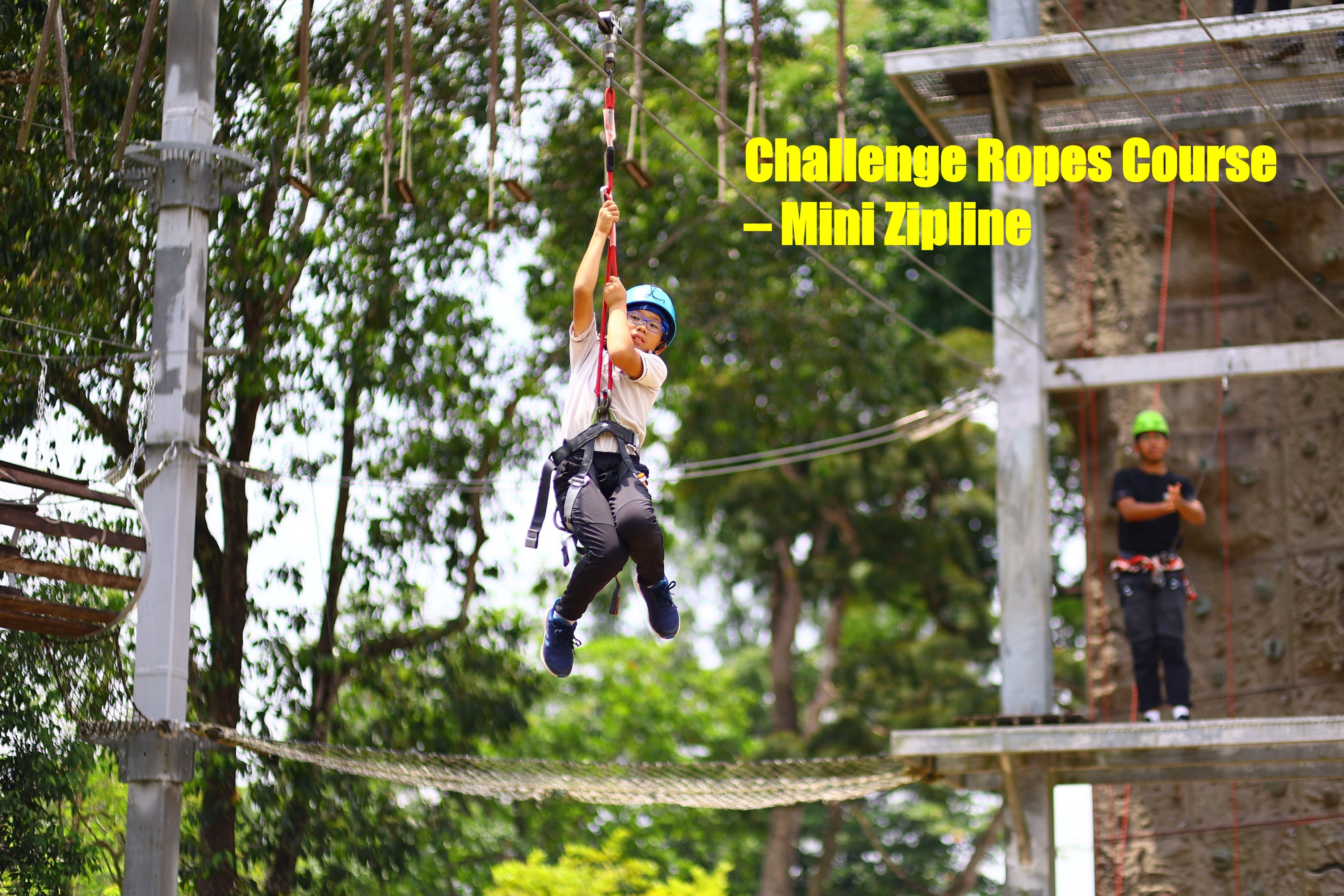 A P5 boy involved in the challenge ropes course doing the mini zipline